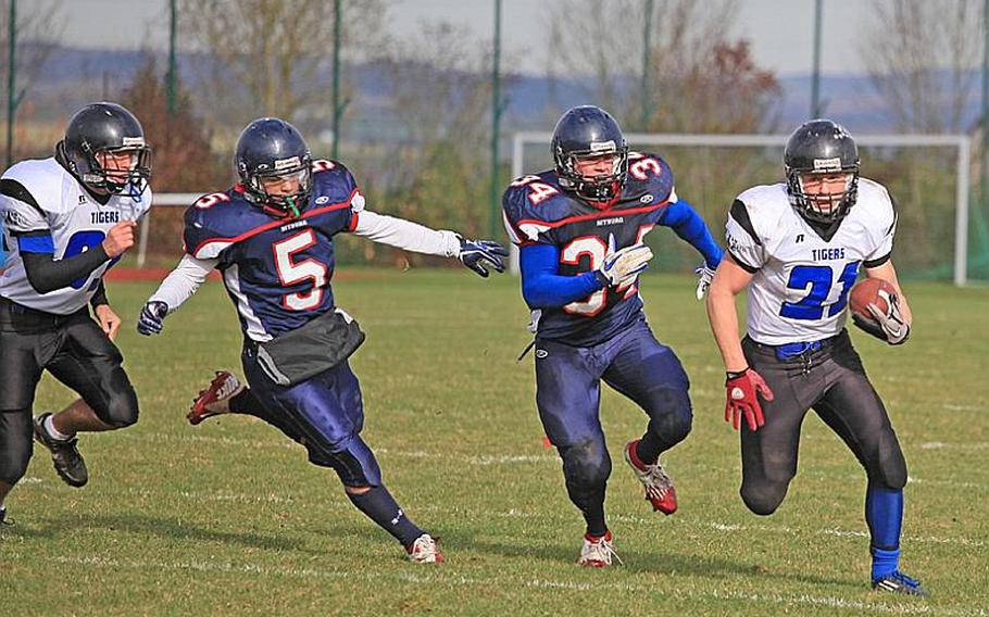 Bitburg's Kenny Love, 5, and Bryson Randall, 34, chase Hohenfels sophomore running back David Vidovic, 21, during the Barons' 56-14 home win Saturday.