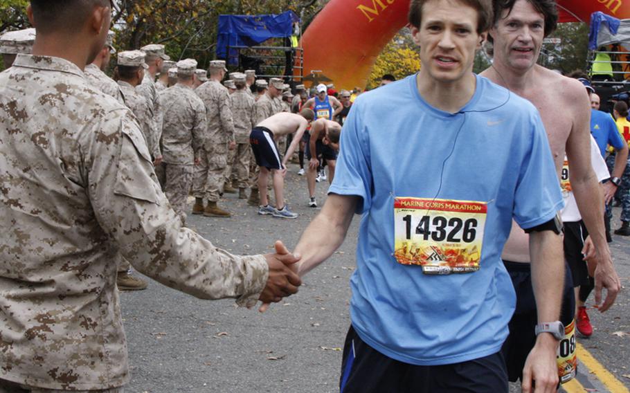 Marines line the finish line to congratulate runners finishing the Marine Corps Marathon on Oct. 28, 2012.