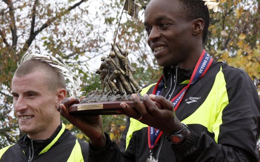 Army Spc. Augustus Maiyo (right) displays his trophy after winning the men's division of the Marine Corps Marathon on Oct. 28, 2012. Maiyo finished with a time of 2:20:20. Army Capt. Kenneth Foster (left) came in second with a time of 2:22:39.