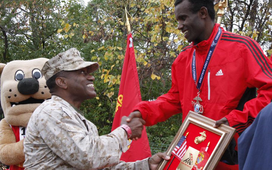 Lt. Gen. Willie Williams presents Birhanu Tadesse with a plaque at the 2012 Marine Corps Marathon awards ceremony on Sunday, Oct. 28. Tadesse finished third place with a time of 2:23:03.