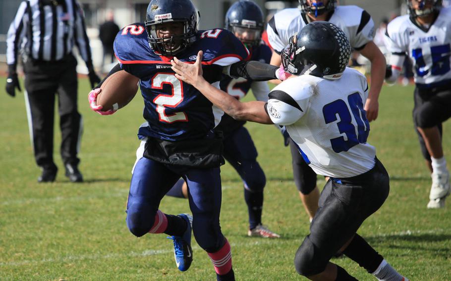 Bitburg running back C.J. Evans stiff arms Hohenfels' P.J. McCune in the first half of the Barons' 56-14 semifinal romp over the visiting Tigers, Saturday. The Barons will face Naples in the Division II championship game.