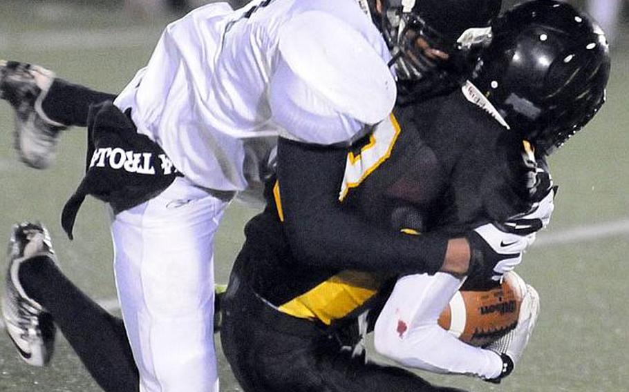 Zama American defender Mitchell Harrison wrestles down American School In Japan ball carrier Ken Yajima during Friday's Kanto Plain Association of Secondary Schools football game in Tokyo. ASIJ came from behind 19-7 to win 20-19.