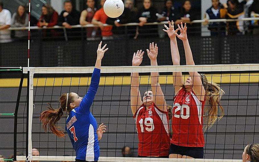 Jordan Hansey knocks a ball over the net as Lakenheath's Kaelan Rasmussen and Eliza Evans attempt to block. Ramstein won the Division I match 25-16, 25-20.