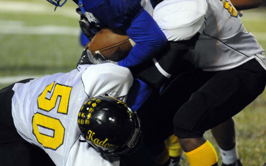 Yokota running back Kalik Battle gets brought down by Kadena defenders Tyler Putt, left, Barry Mitchell  and Justin Sego, rear, during Saturday's DODDS Pacific Far East Division I regular-season game at Yokota Air Base, Japan. Yokota won 52-12 and will host the D-I title game on Nov. 17 against Kubasaki.