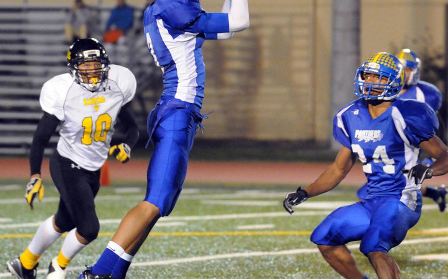 Yokota defensive back Mikey Henagan picks off a Kadena pass as Kadena's Jalen Amos and Yokota's Raymond Butlerwatch during Saturday's DODDS Pacific Far East Division I regular-season game at Yokota Air Base, Japan. Yokota won 52-12 and will host the D-I title game on Nov. 17 against Kubasaki.