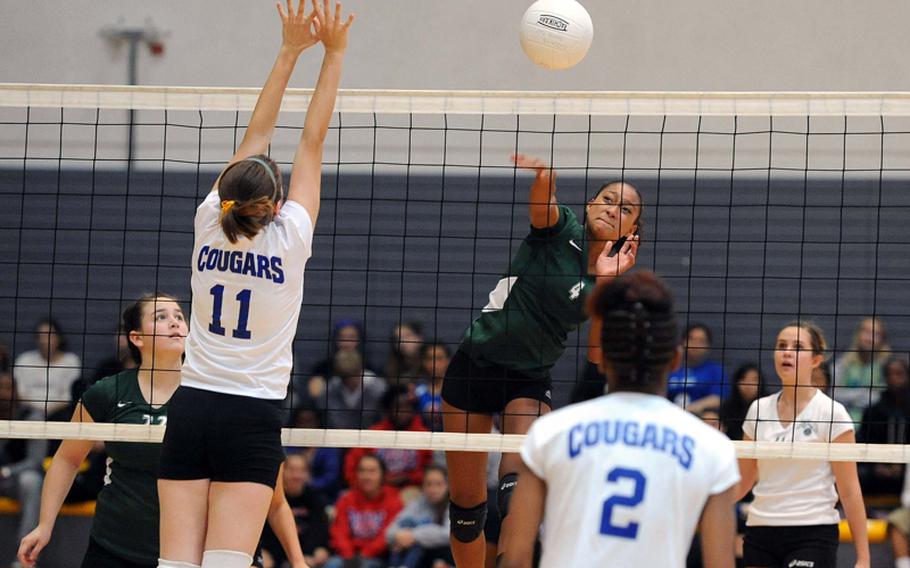 Laneisha Jeans of Naples hits the ball over the net as Ansbach's Duplessie Lauren, left, tries to defend in the Division II title match at the DODDS-Europe volleyball championships in Ramstein, Saturday. The defending champs beat Ansbach 23-25, 25-20, 25-17, 25-18.