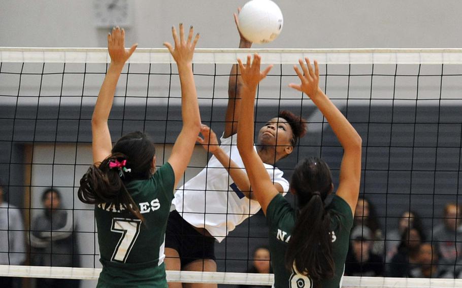 Ansbach's Caprice Lockett hits the ball over the Naples block of Victoria, left, and Isabel Krause in the Division II title match at the DODDS-Europe volleyball championships in Ramstein, Saturday. The defending champs beat Ansbach 23-25, 25-20, 25-17, 25-18.