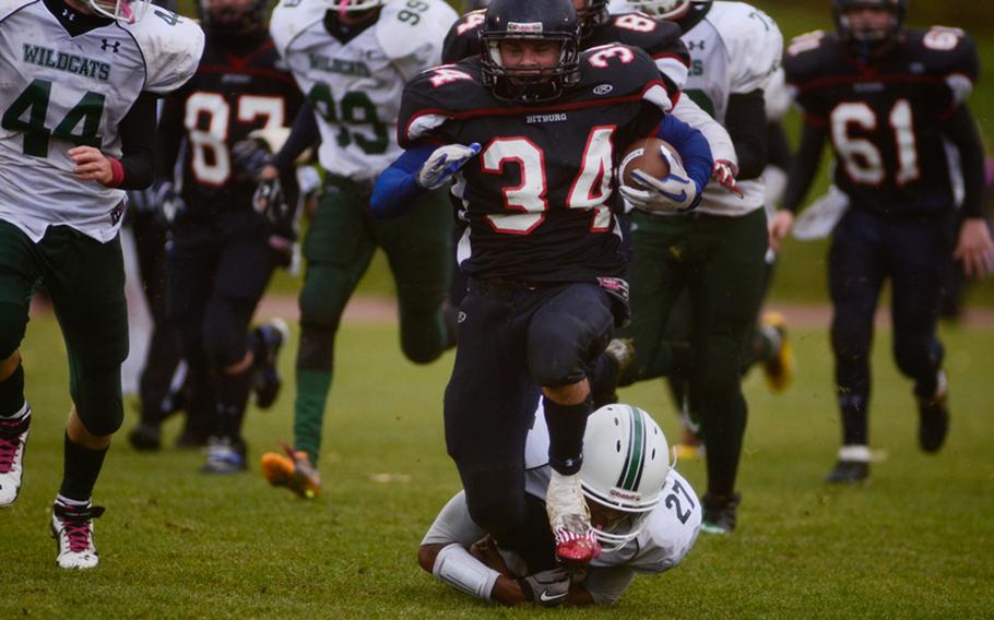 Bitgurg's Bryson Randall is tackled from behind by Naples' Howard Pulley Saturday evening in the 2012 DODDS-Europe Division II football championship in Baumholder, Germany. Bitburg edged Naples 22-20 to win its record fourth championship in a row.