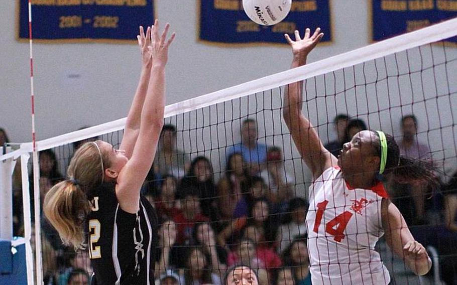 Nile C. Kinnick middle blocker Audri Salter tries to hit past the block of American School In Japan's Mia Weinland during Saturday's championship match in the Far East High School Girls Division I Volleyball Tournament at Guam High School. ASIJ repeated its championship, beating Kinnick for the second straight year 25-17, 21-25, 25-20, 25-20.