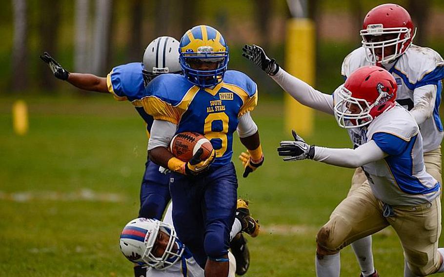 DODDS-Europe South All-Star football team member  Demar Flake of Ansbach High School breaks through a swarm of defenders Saturday afternoon in Vilseck, Germany as the South All-Stars defeated the North 29-10.