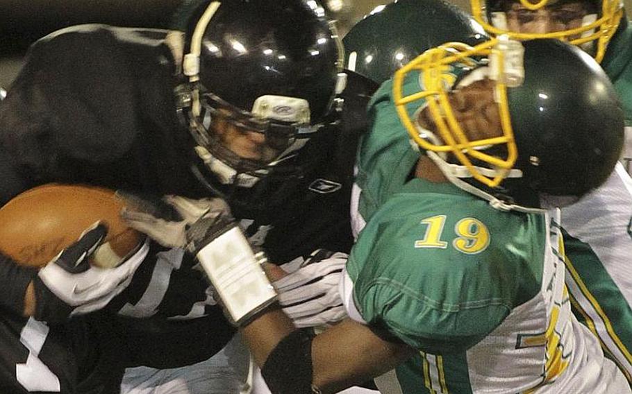Zama American's Mitchell Harrison battles Robert D. Edgren defender Ben Warren for yards during Saturday's DODDS Pacific Far East High School Division II football championship game at Camp Zama, Japan. Zama beat Edgren 35-20 for its second D-II title in four years.