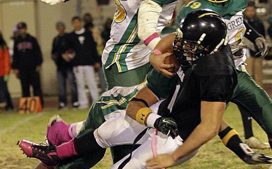 Zama American running back Andre Encarnacion gets upended by Robert D. Edgren defenders Ismail Leon, clockwise from bottom,  Khalil Williams and Ben Warren during Saturday's DODDS Pacific Far East High School Division II football championship game at Camp Zama, Japan. Zama beat Edgren 35-20 for its second D-II title in four years.