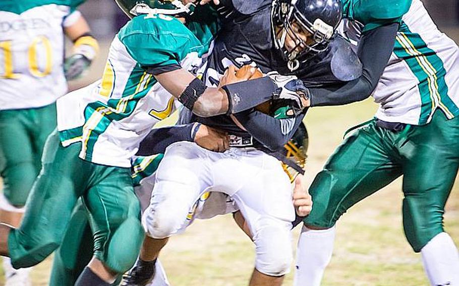 Zama American running back Rafael Morales gets sandwiched by Robert D. Edgren defenders Ben Warren and Louis Murphy during Saturday's DODDS Pacific Far East High School Division II football championship game at Camp Zama, Japan. Zama beat Edgren 35-20 for its second D-II title in four years.