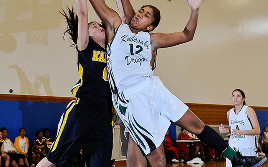Kubasaki's Sydney Johnson and Kadena's Nia Rodriguez collide as they battle for the ball during Sunday's girls championship game in the 7th Okinawa-American Friendship Basketball Tournament at Kadena Air Base, Okinawa. Kadena defended its title 62-23.