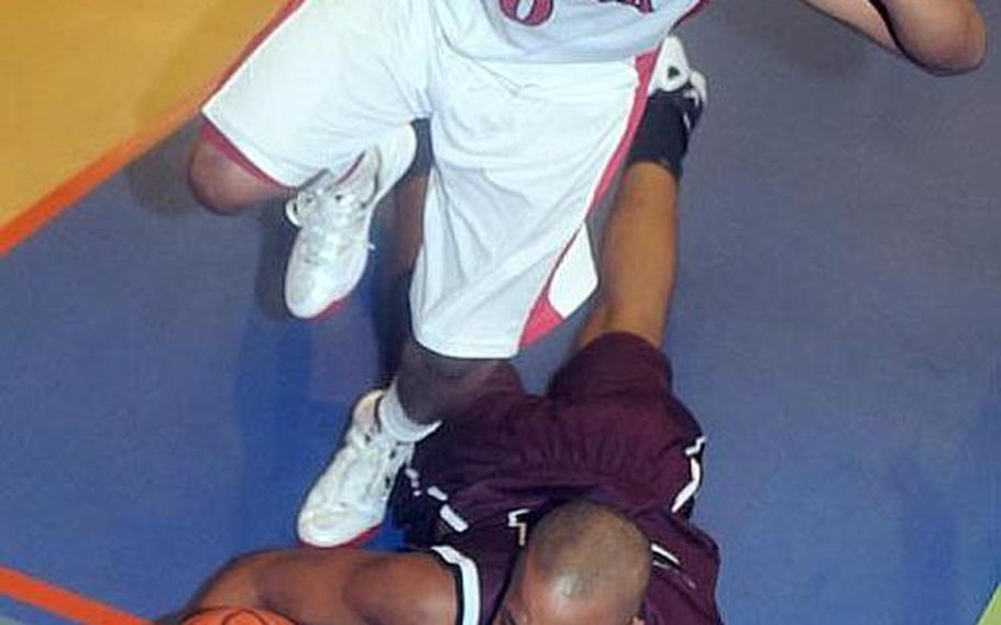 Malik White of Nile C. Kinnick leaps over David Eason of Matthew C. Perry as the ball goes out of bounds during the boys opening game in the 2012 DODDS Japan basketball tournament. They're back with their respective teams, who will do battle Friday and Saturday in the DODDS Japan tournaments at Misawa Air Base.