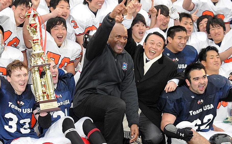 U.S. Army Japan commanding officer Maj. Gen. Michael Harrison and former Japanese prime minister Taro Aso are flanked by Aaron Stravers, Dustin Kimbrell and Roland Cote of Team USA and members of Team Japan after the 2012 Tomodachi Bowl at Yokosuka Naval Base, Japan. Team USA, comprised of Yokota, Zama American, Nile C. Kinnick and American School In Japan players, beat Team Japan 50-17. This year's game is scheduled for 2 p.m. Sunday at Yokota High School.