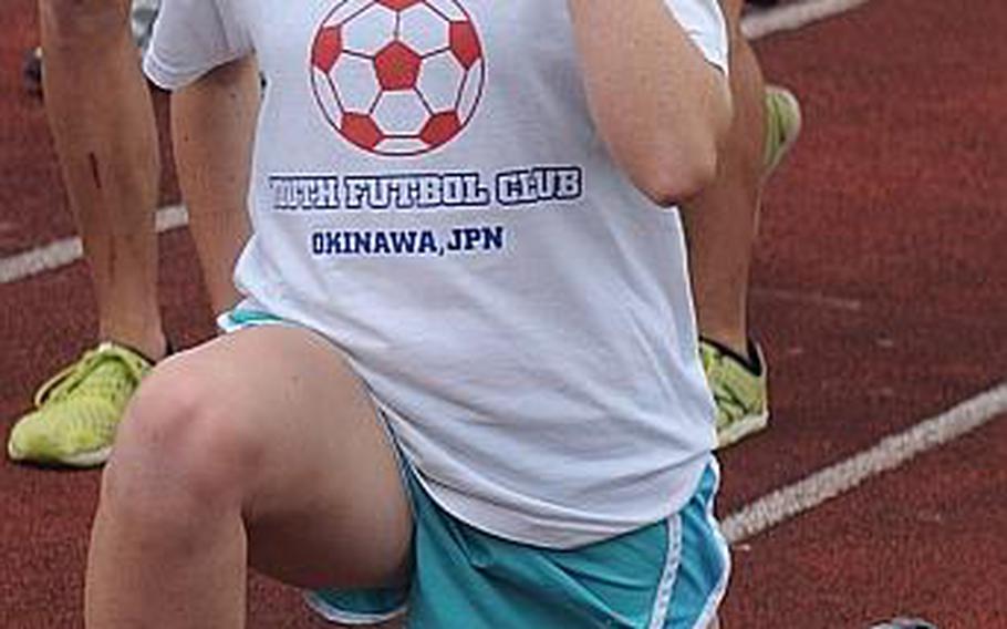 Kubasaki sophomore distance runner Jessica Ircink performs lunges during warmup for practice Wednesday at Camp Foster, Okinawa. Ircink ran the 1,600 in last Saturday's meet at Chatan Stadium in 5 minutes, 29.87 seconds, just shy of the Pacific record of 5:24.28.