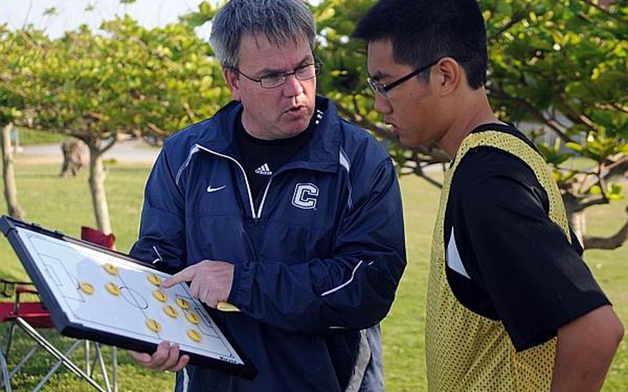 Kadena volunteer coach Mike Callahan gives instructions to player Jacob Baysa during Monday's Okinawa Activities Council high school boys soccer match at Okinawa Christian School International, Yomitan. Callahan is back with the Panthers after a seven-year absence, joining team sponsor Nelson Youngblood's staff as the team's "tactician," Youngblood said.