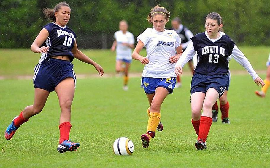 Menwith Hill's Arielle Rogers, left, sweeps in to help teamate Evita Paul-Aragon defend against Sigonella's Michelle Creollo. Sigonella won the Division III game on opening day of the DODDS-Europe soccer championships 1-0.