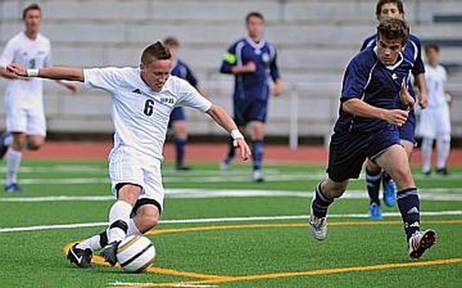 Dylan Kessler of Naples gets a shot off as Bitburg's Kenny Love comes in to defend. Naples beat the Barons 4-0.