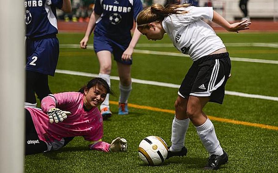 Naples' Tyler Treat kicks a rebound past Bitburg's goalie, Isabella Madamba, Wednesday afternoon in the third day of the DODDS-Europe soccer championships at Vogelweh, Germany.