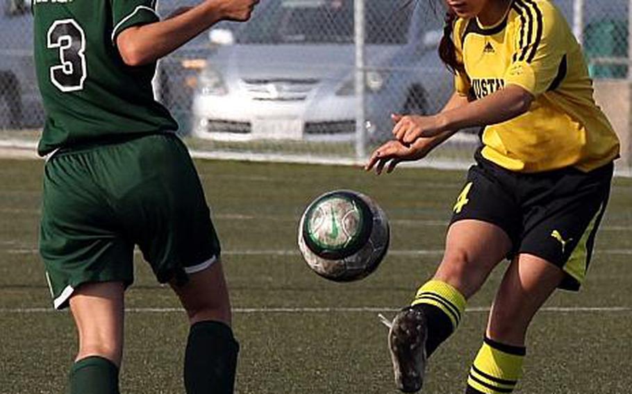 American School In Japan's Christina Higa launches a kick past Kennedy Salazar of Kubasaki during Thursday's championship match in the Far East High School Girls Division I Soccer Tournament at Yokosuka Naval Base, Japan. The Mustangs dethroned the Dragons 2-0.