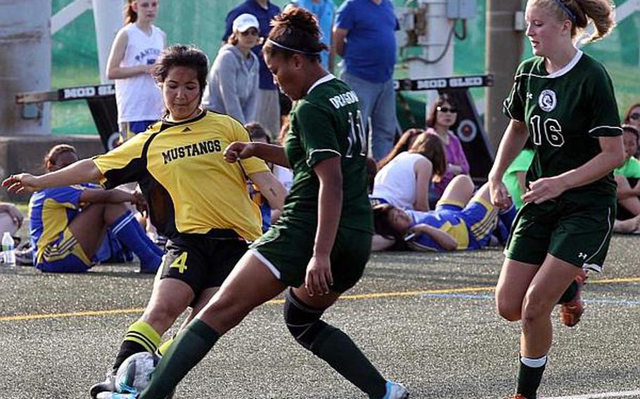 American School In Japan's Christina Higa battles for possession against Alyssa Smith and Peyton Lewis of Kubasaki during Thursday's championship match in the Far East High School Girls Division I Soccer Tournament at Yokosuka Naval Base, Japan. The Mustangs dethroned the Dragons 2-0.