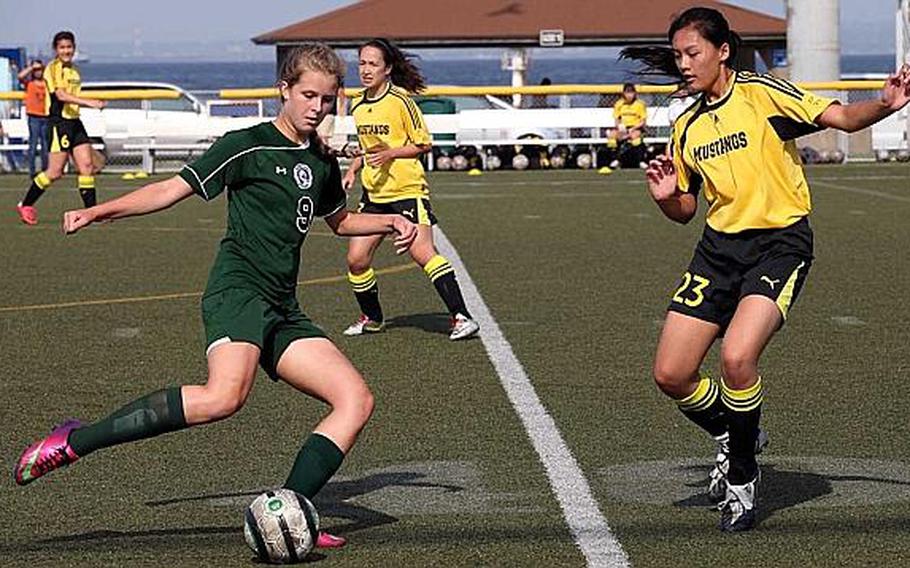 Stephanie Dowse of Kubasaki looks to boot the ball past Celeste Lim of American School In Japan during Thursday's championship match in the Far East High School Girls Division I Soccer Tournament at Yokosuka Naval Base, Japan. The Mustangs dethroned the Dragons 2-0.