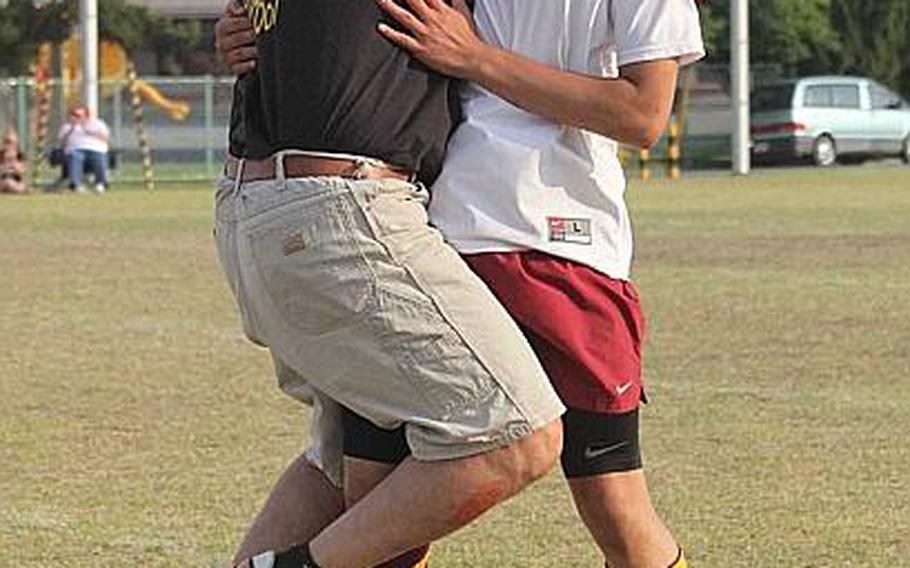 The air up there. Coach Mark Lange and player Jon Cadavos get an airborne hug in celebration of their Far East High School Boys Division II Soccer Tournament title. Matthew C. Perry repeated their title, beating Osan American 3-1 in Thursday's final.