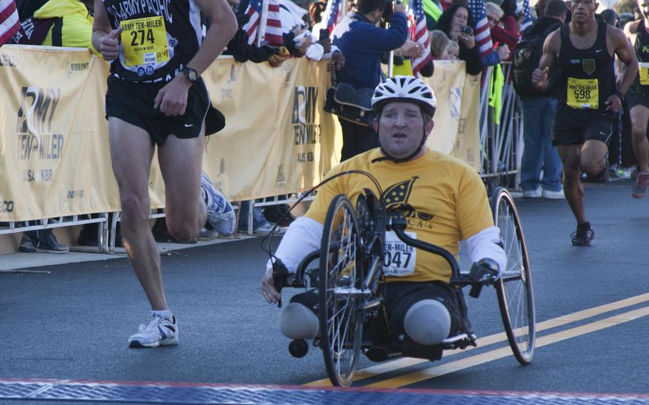 A wounded warrior crosses the finish line of the 29th annual Army 10-Miler race outside the Pentagon on Oct. 20, 2013.