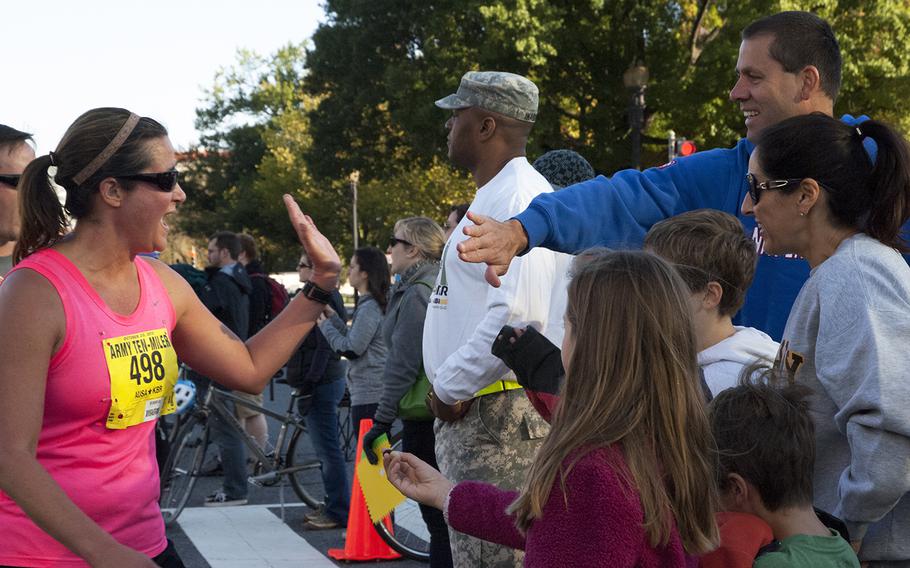 Sarah Luebbert of Elizabethtown, Ky. high-fives a spectator at the Army 10-Miler, Oct. 20, 2013, in Arlington, Va. and Washington, D.C.