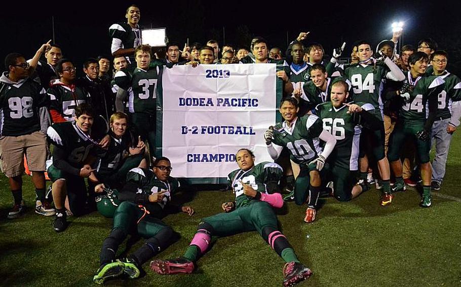 Daegu players celebrate with the banner following Friday's Far East High School Division II football championship game at Camp Walker, South Korea. The Warriors beat the Robert D. Edgren Eagles 33-12, their third D-II title in four years; they're now 3-2 overall in D-II finals dating back to 2007.