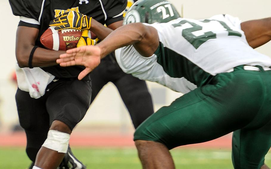 Kadena running back Barry Mitchell is met by Kubasaki defender Tyshon Butler during Saturday's DODDS Pacific Far East High School Division I football championship game at Kadena Air Base, Okinawa. Kubasaki beat Kadena 34-31 in overtime.