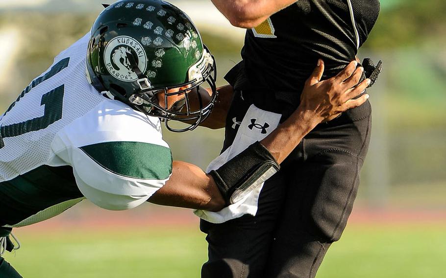 Kadena running back Justin Sego tries to rush past Kubasaki defender Deaven Curtis during Saturday's DODDS Pacific Far East High School Division I football championship game at Kadena Air Base, Okinawa. Kubasaki beat Kadena 34-31 in overtime.