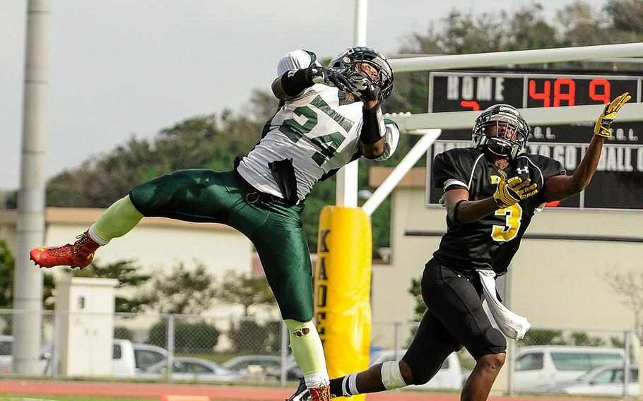 Kubasaki defender Jarrett Mitchell and Kadena receiver Barry Mitchell engage in a tip drill during Saturday's DODDS Pacific Far East High School Division I football championship game at Kadena Air Base, Okinawa. Barry Mitchell caught the pass for a 24-yard touchdown just before halftime; Kubasaki beat Kadena 34-31 in overtime.