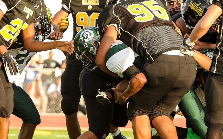 Kubasaki quarterback DeQuan Alderman slithers through the tackle of Kadena defender Siu Fuimaono for the game-winning touchdown in overtime during Saturday's DODDS Pacific Far East High School Division I football championship game at Kadena Air Base, Okinawa. Kubasaki beat Kadena 34-31 in overtime.