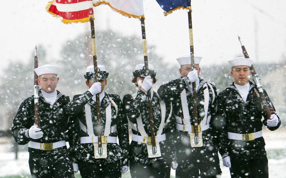 A Navy honor guard brings the colors onto the field prior to Friday's Army-Navy flag-football rivalry game at Misawa Air Base, Japan. Naval Air Facility Misawa beat the Army's 708th Military Intelligence Detachment 27-0 in a game played in wind-blown snow with temperatures around freezing.