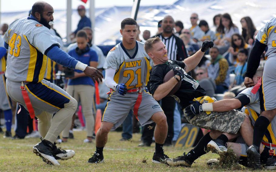 Navy's Joe King and Howard Gomez close in on Army running back Brent Owens during Saturday's 24th Army-Navy flag-football rivalry game at Torii Station, Okinawa. Army rallied to win 27-15.