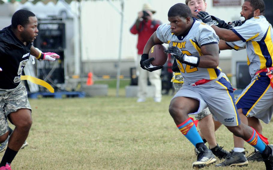 Navy running back Quentin Foley charges toward Army defender Brandon Hunter during Saturday's 24th Army-Navy flag-football rivalry game at Torii Station, Okinawa. Army rallied to win 27-15.