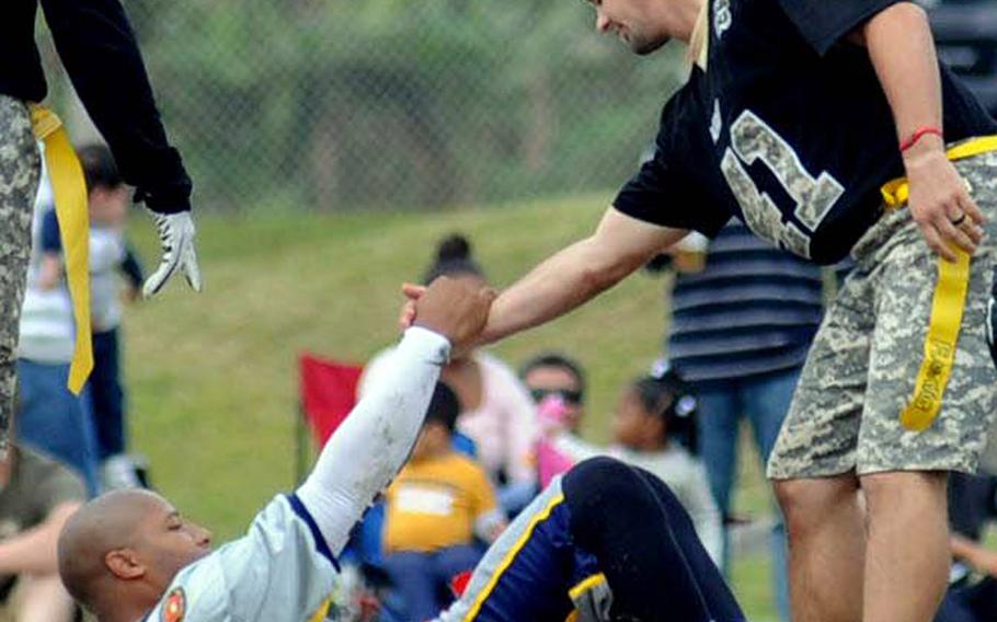 Army defender Drew Majors helps Navy quarterback Sanford James to his feet during Saturday's 24th Army-Navy flag-football rivalry game at Torii Station, Okinawa. Army rallied to win 27-15.