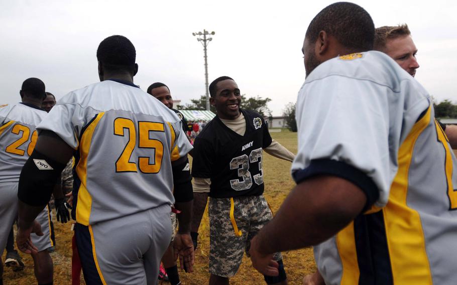 Army's Gerhon Teague and his teammates accept congratulations from the Navy side after Saturday's 24th Army-Navy flag-football rivalry game at Torii Station, Okinawa. Army rallied to win 27-15.
