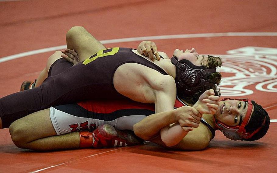 Kaiserslautern's Carlos Muniz, bottom and Baumholder's Michael Holliday wrestle for the 113-pound weight class title in the Central Sectional Wrestling Championships at Kaiserslautern, Germany, Saturday, Feb. 8, 2014. Muniz went on to defeat Holliday.