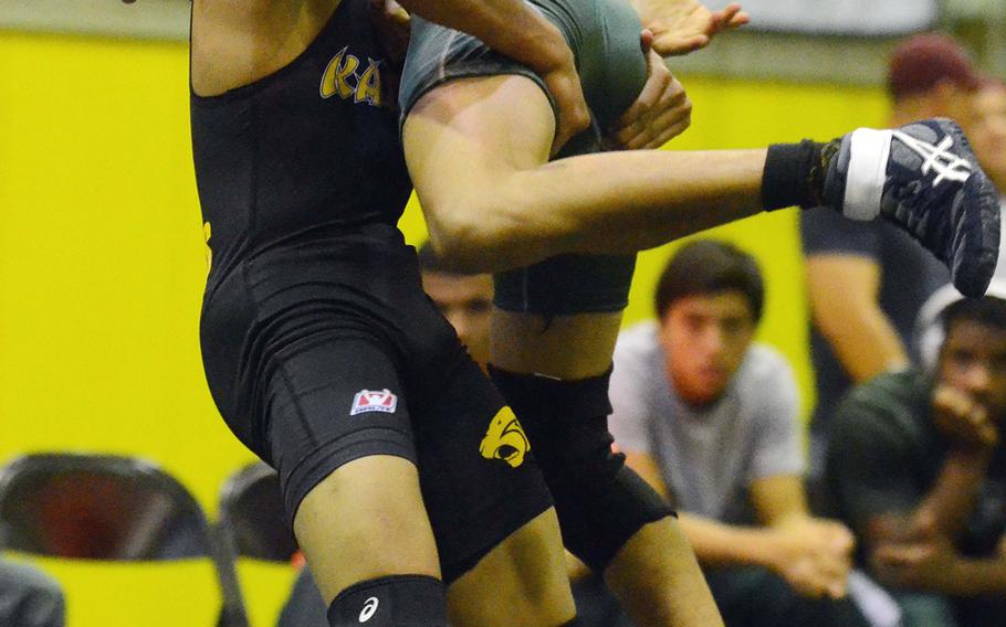 In a battle of former Far East tournament champions, Kadena's Justin Duena is shown lifting Kubasaki's  Daniel Mora in the 115-pound bout of an Okinawa wrestling meet last month at Kadena. Duenas won at 101 pounds in 2012 and Mora beat Duenas for the 108 title last year.