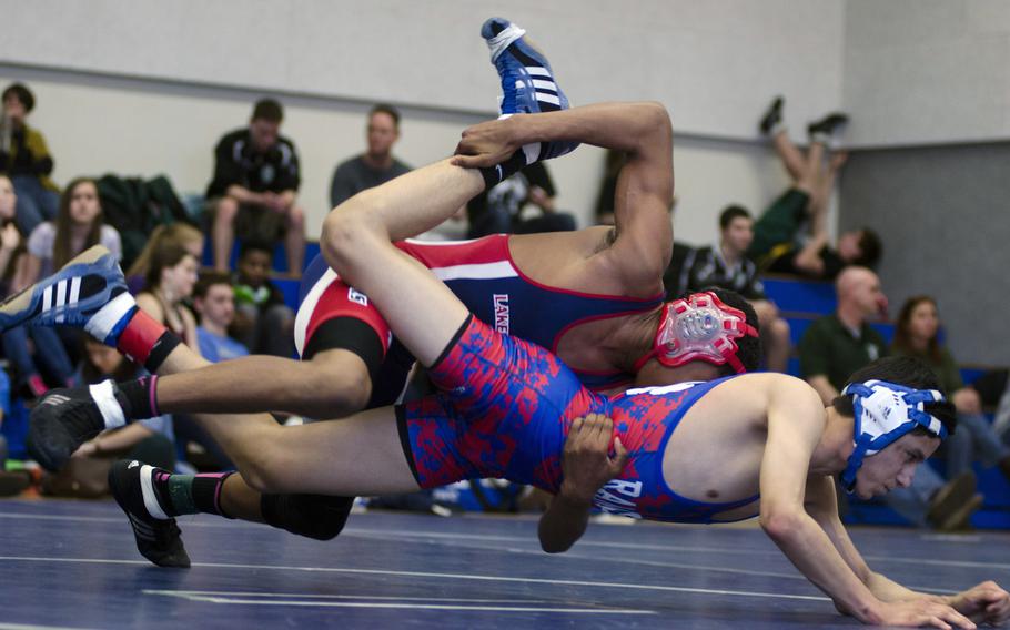 Benjamin Lovett with Lakenheath holds onto Mike Montano with Ramstein as they fall to the floor during a match for first place in the 132-pound bracket at Brussels American School, Belgium, on Saturday, Feb. 8, 2014. Lovett went on to win the match and both wrestlers earned a spot at this weekend's European Championships in Wiesbaden, Germany.

Adam L. Mathis/Stars and Stripes