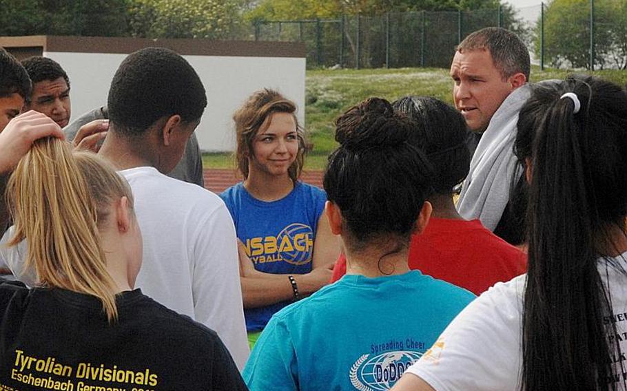 Ansbach senior Mykala Bazen and her teammates huddle around Cougars track coach and athletic director Michael Jimerson during a recent practice session at Ansbach. Bazen is the reigning DODDS-Europe 300-meter hurdles champion and a collegiate track and field prospect.