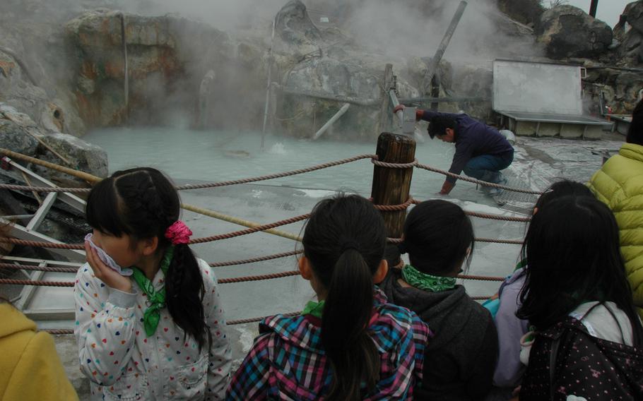 Children watch a man cooking eggs in a hot spring at Hakone, Japan. The resort town known for its thermal spas (onsens) is about a 90-minute drive from U.S. military bases in Japan.