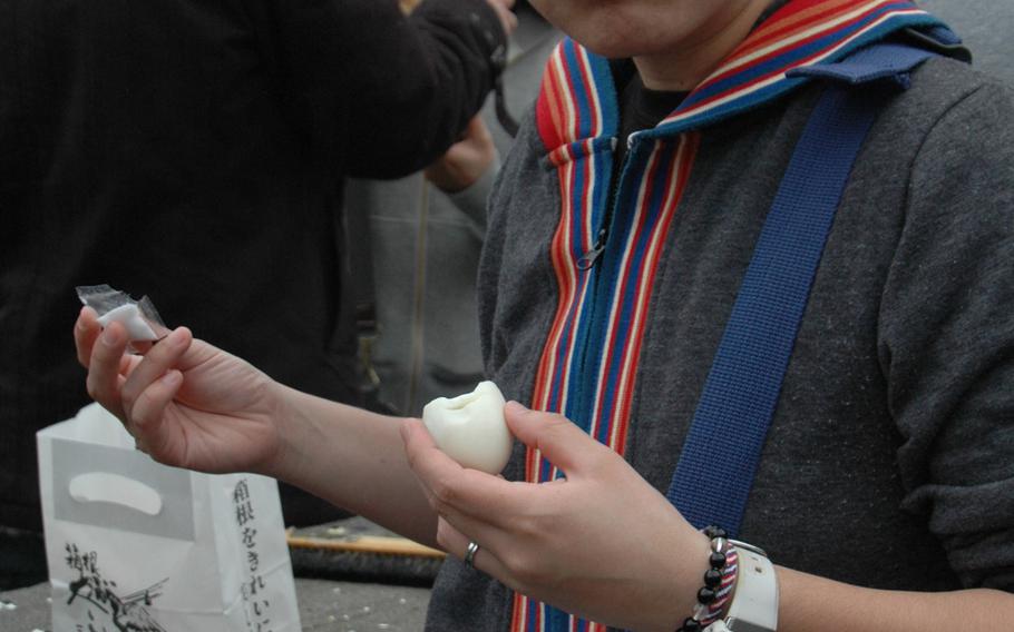 A tourist enjoys some black eggs at Hakone, Japan. The eggs are cooked in an onsen, and the sulfur in the water turns the shells black. 