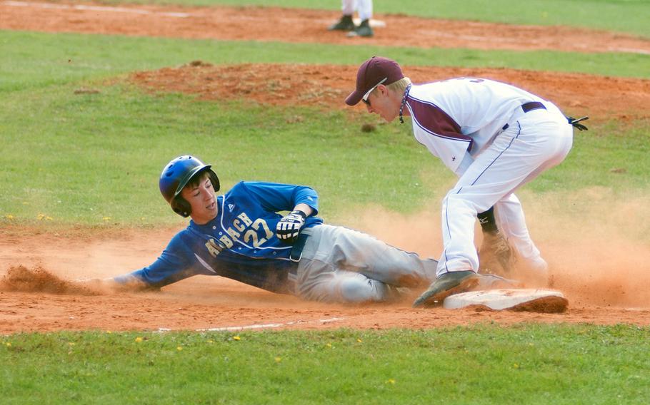 Ansbach's Brandon Piccinini slides into third as Baumholder's Taylor Moore trys to get the tag out during the doubleheader between the Cougars and the Buccaneers, April. 19, 2014, in Ansbach.