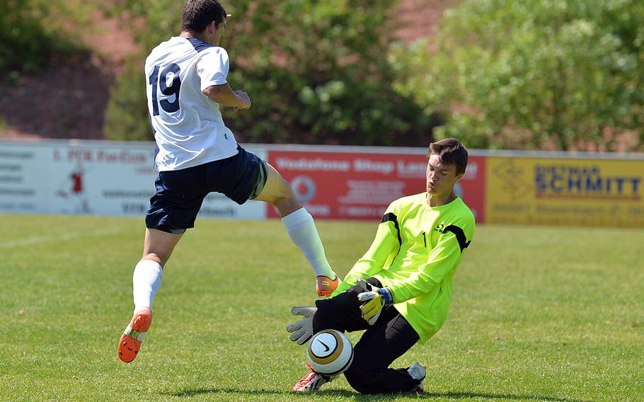 Alconbury keeper Luke Kobes makes a stop on Aviano's Mike Trujillo in a opening day Division II match at the DODDS-Europe soccer championships in Reichenbach, Germany, Monday, May 19, 2014. Kobes' efforts were for naught as the Saints won the game 6-0.