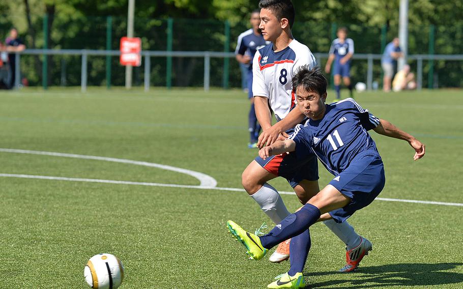 Black Forest Academy's JinHwan Kim gets a shot off against Aviano's Dallas Arzate in BFA's 3-2 win over the Saints in a opening day Division II match at the DODDS-Europe soccer championships in Reichenbach, Germany, Monday, May 19, 2014.